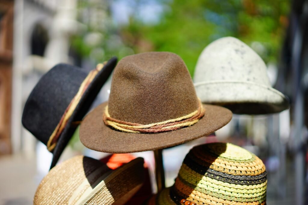 A vibrant display of fashionable fedoras stacked outdoors. Perfect for sun protection and style.