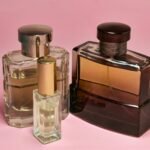 Three stylish perfume bottles with elegant caps on a pink backdrop, capturing a sense of luxury and sophistication.